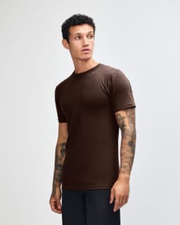 A brown unisex fine jersey short sleeve T-shirt displayed on a model from the side. Features a logo.
