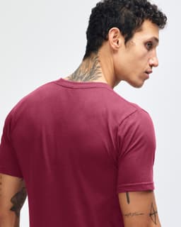 A maroon American Apparel fine jersey short sleeve T-shirt displayed on a model from the back, featuring a logo.
