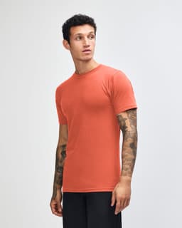A side view of an orange unisex short sleeve t-shirt with a logo on it.