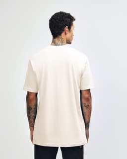 A cream-coloured unisex short sleeve T-shirt, viewed from the back, featuring a logo.