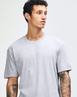 A unisex fine jersey short sleeve T-shirt in grey, paired with black skinny jeans and white sneakers.