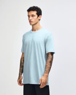 A unisex fine jersey short sleeve t-shirt in light blue, displayed on a model from a side angle.