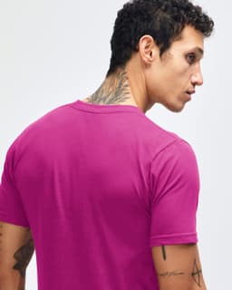 A pink short sleeve T-shirt featuring a simple design and a small logo on the back.