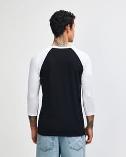 A black and white unisex raglan T-shirt featuring three-quarter sleeves and a logo on the back.