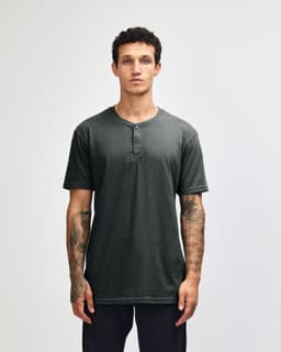 A unisex Henley T-shirt in a dark grey colour with a three-button placket and short sleeves. It features a logo.