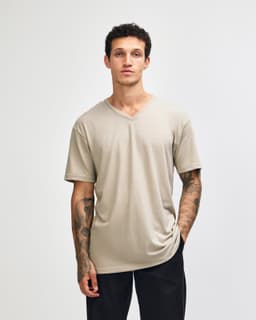 A beige unisex V-neck T-shirt made from CVC fabric, featuring short sleeves and a logo.