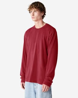 A long sleeve, fine jersey t-shirt in a deep red colour, displayed on a model wearing light blue jeans.