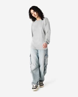 A model wears a grey American Apparel long sleeve T-shirt with loose-fitting cargo jeans. The image features branding.