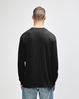 A black long sleeve t-shirt displayed on a model, featuring a simple design and a logo on the back.