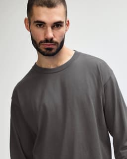 A long sleeve adult t-shirt in grey, featuring a simple design and a logo on the shirt.