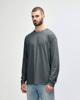 A dark navy long sleeve t-shirt is displayed on a model, featuring a logo on the sleeve.