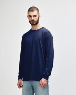 A navy long sleeve t-shirt on a model, featuring a round neckline and a simple design. The shirt has a logo.