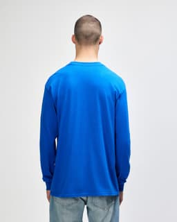 A blue long sleeve t-shirt with a round neckline, viewed from the back, worn by a person.