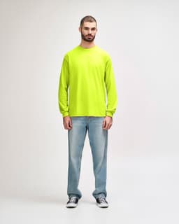 A model wearing a bright yellow long sleeve T-shirt paired with black jeans and sneakers, featuring a logo.