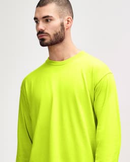 A bright yellow long sleeve t-shirt with a relaxed fit. It features a logo on the front.