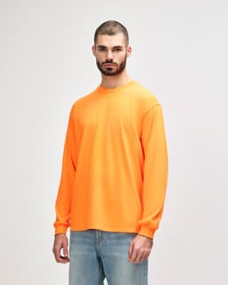 An orange long sleeve t-shirt displayed on a model, featuring a plain design and a logo.