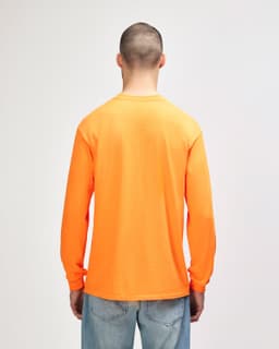 An orange long sleeve T-shirt displayed on a model, featuring a simple design and a logo.