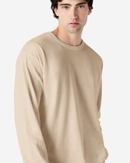 A beige long sleeve t-shirt for adults, featuring a round neckline and a fitted silhouette. It has a logo on it.