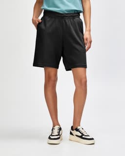 Unisex black pique gym shorts with an elastic waistband and side pockets, featuring a logo.