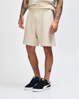 Beige unisex gym shorts with an elastic waistband and pockets, featuring a logo on the side.