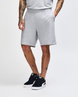 Light grey unisex gym shorts with an elastic waistband and side pockets, displayed on a model from the side.