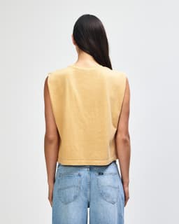 A back view of a women's muscle T-shirt in a light yellow hue, with a casual fit and no sleeves.