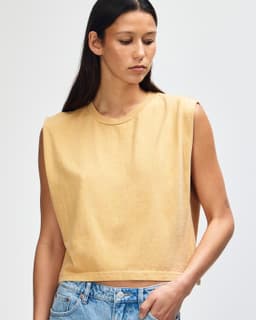 A muscle t-shirt in a soft yellow hue, featuring a crew neck and wide armholes. The shirt has a logo on it.