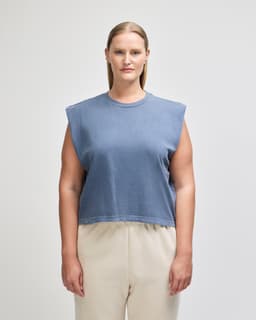 A navy blue women's muscle t-shirt with wide sleeves, displayed on a model, featuring a branded logo.