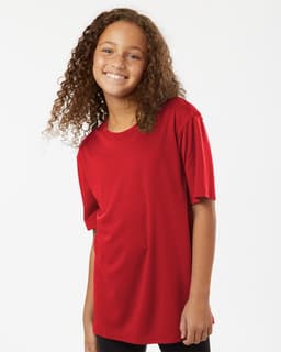A red Youth Pro-Lock Performance T-Shirt displayed on a smiling child with curly hair, wearing black pants.