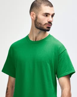 A green Gildan Heavy Cotton Adult T-Shirt displayed on a model, featuring a simple design and a logo.