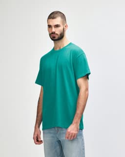 A turquoise Gildan Heavy Cotton Adult T-Shirt displayed on a male model, featuring a simple design and a logo.
