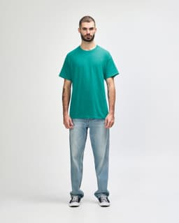 A turquoise Gildan Heavy Cotton Adult T-Shirt displayed on a male model, paired with black jeans and sneakers.