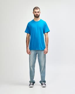 A turquoise Gildan Heavy Cotton adult T-shirt displayed on a model wearing black jeans and sneakers.