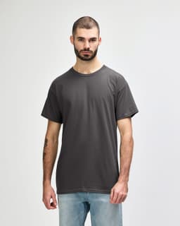 A grey Gildan Heavy Cotton Adult T-Shirt worn by a model, featuring a classic crew neck design and short sleeves.