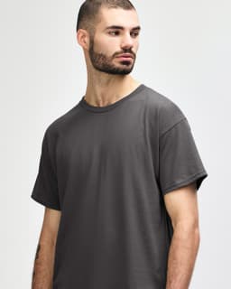 A grey Gildan Heavy Cotton adult T-shirt displayed on a male model with a neutral background.