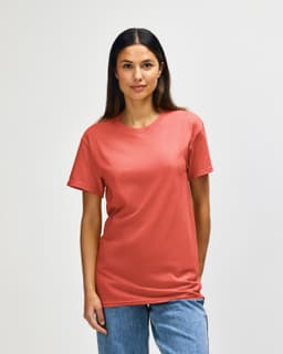 A side view of a man wearing a coral Gildan Heavy Cotton adult t-shirt with short sleeves.