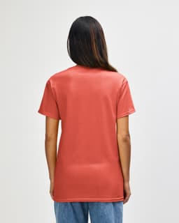 A person wearing a coral Gildan Heavy Cotton Adult T-shirt, viewed from the back, showcasing its simple design.