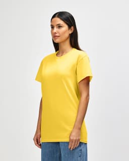 A yellow Gildan Heavy Cotton Adult T-Shirt on a model, featuring a logo. The shirt has a classic fit and short sleeves.