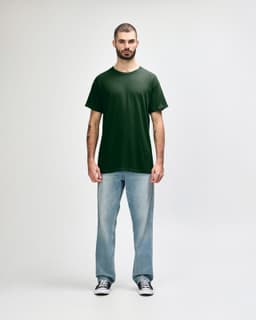 A green Gildan Heavy Cotton adult T-shirt displayed on a male model, paired with black jeans and sneakers.