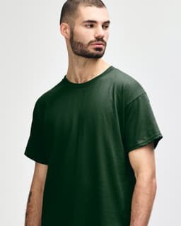 A dark green Gildan Heavy Cotton adult t-shirt with a crew neck and short sleeves. It features a logo.