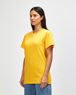A model wearing a bright yellow Gildan Heavy Cotton adult T-shirt, standing against a plain background.
