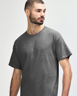 A grey Gildan Heavy Cotton Adult T-Shirt displayed on a model, featuring a simple design and a logo.