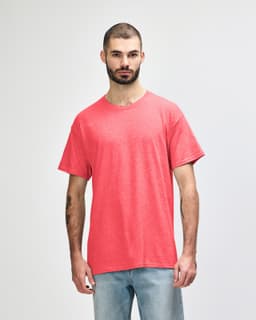 A model wearing a vibrant coral Gildan Heavy Cotton Adult T-Shirt with a relaxed fit.