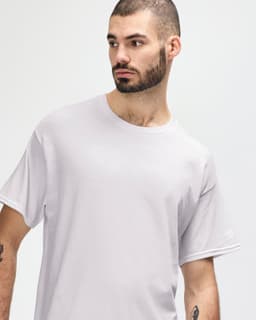 A man models a white Gildan Heavy Cotton Adult T-Shirt, featuring a round neckline and a simple design.