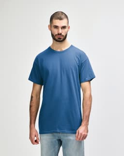 A blue Gildan Heavy Cotton Adult T-Shirt on a model, featuring a plain design and a logo on the label.