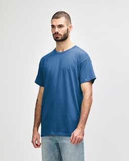 A blue Gildan Heavy Cotton adult t-shirt displayed on a model, featuring a simple design and a logo.