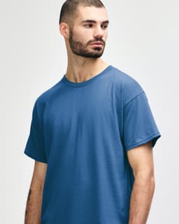 A blue Gildan Heavy Cotton adult t-shirt displayed on a model, featuring a simple design and a logo.