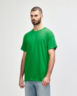 A model wearing a bright green Gildan Heavy Cotton adult T-shirt, standing against a plain background.