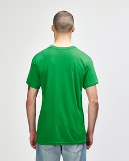 A man wearing a green Gildan Heavy Cotton adult T-shirt, viewed from the back. The shirt has a logo on it.