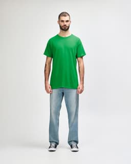 A green Gildan Heavy Cotton adult t-shirt displayed on a mannequin styled with black jeans and sneakers.